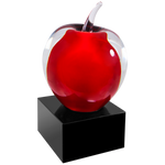 clear and red glass apple on a black glass base